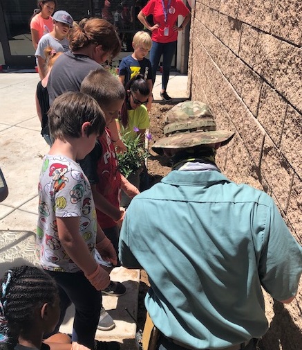 Children outside planting with Grounds